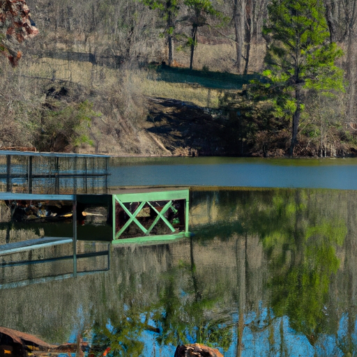 A photograph of a lake with a dock and reflection of the trees in the water